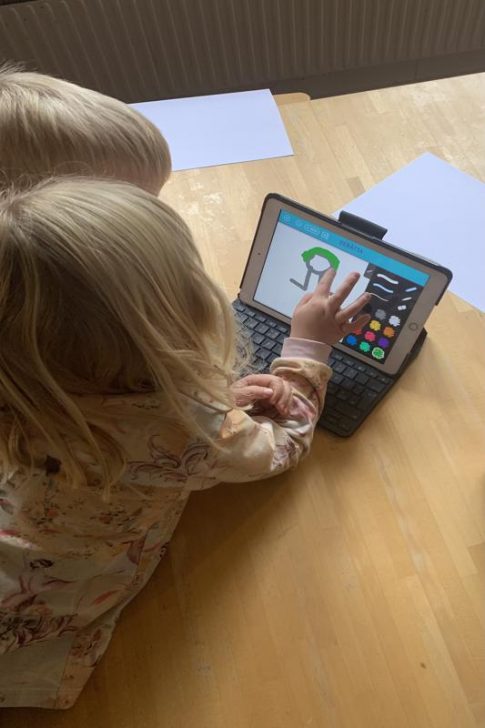 Två barn sitter med en iPad
