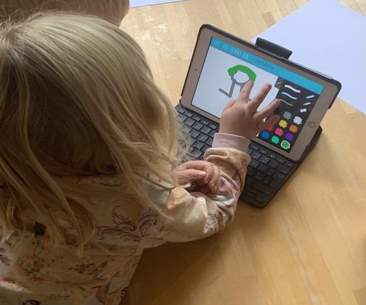 Två barn sitter med en iPad