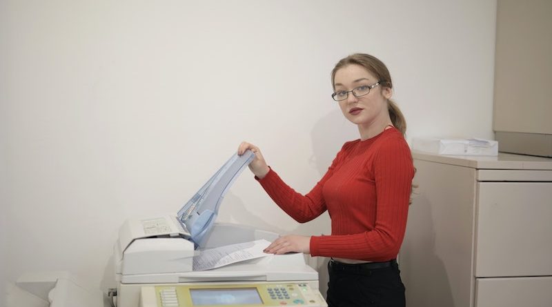 Person står vid en kopieringsmaskin.